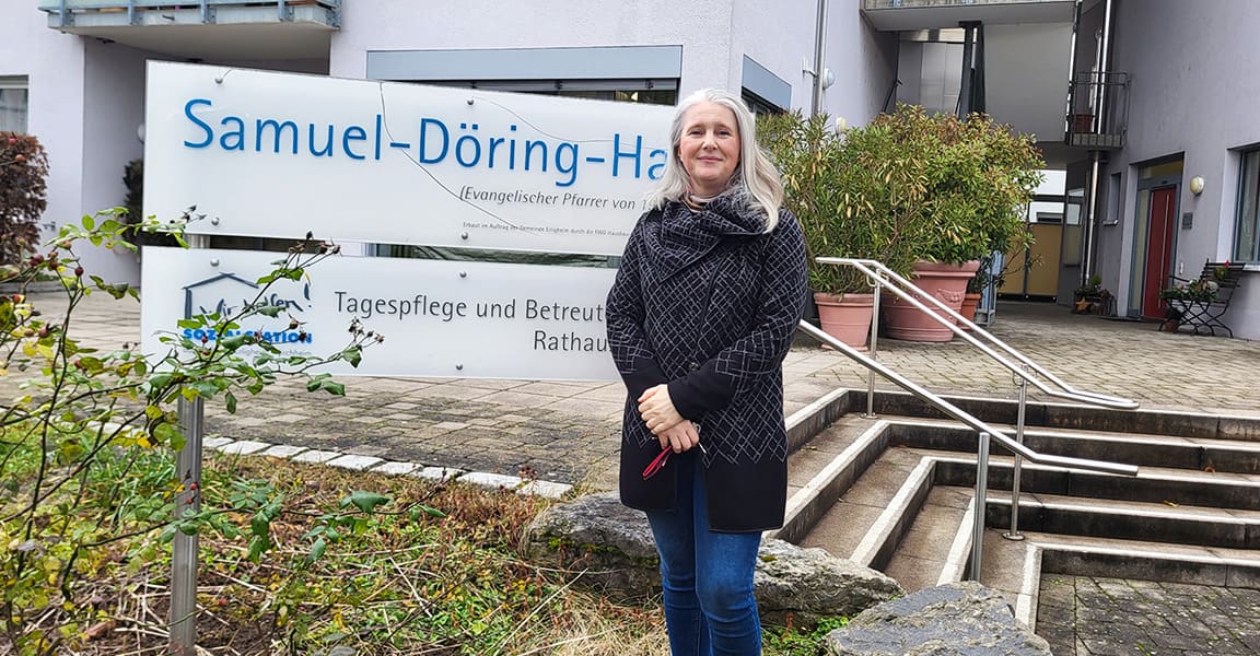 Die Leiterin des Samuel Döhring Hauses steht für dem Schild des Hauses
